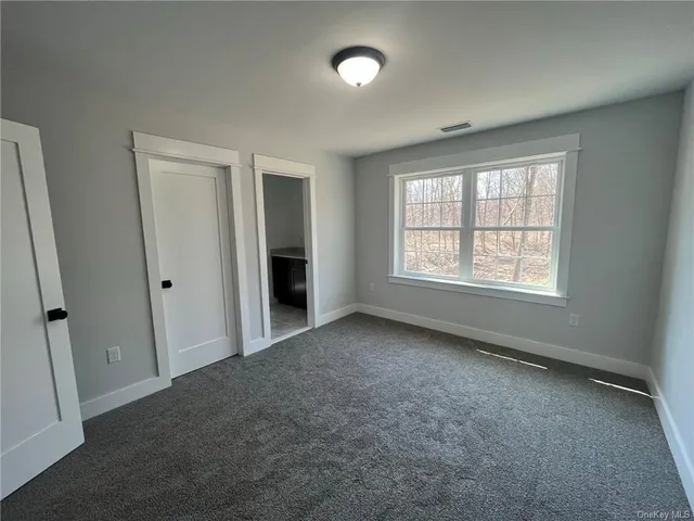 an empty room with windows and closet