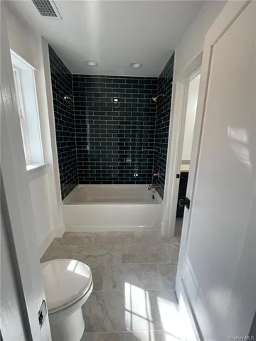 a bathroom with a bathtub and a toilet