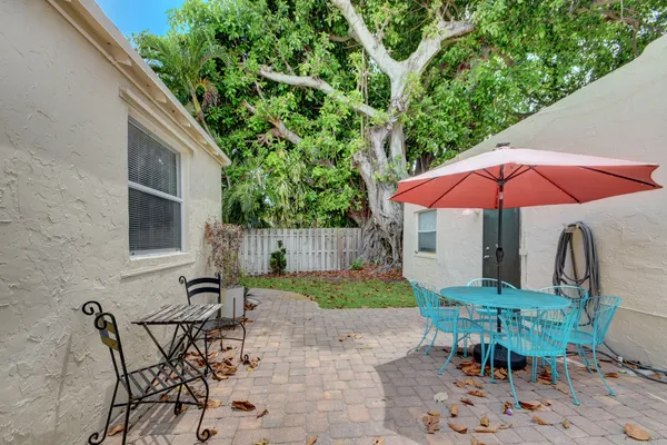 a view of backyard with seating space and wooden fence