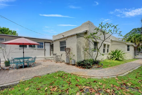 a view of a house with backyard and sitting area