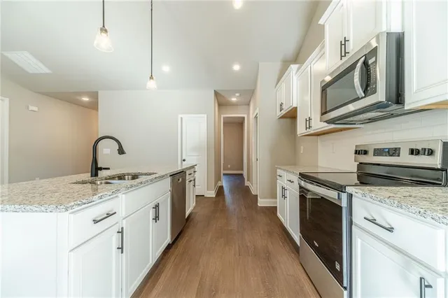 a kitchen with stainless steel appliances granite countertop a sink and cabinets
