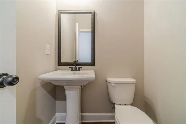 a bathroom with a toilet a sink and mirror