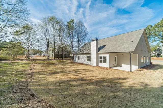 a front view of house with yard and trees around