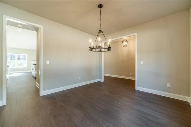 a view of a hallway with wooden floor and chandelier