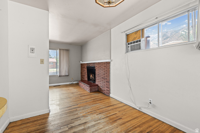 542 East 3400th Street North Provo, UT 84604 - Photo 12 of 39 Living room featuring wood-finish flooring and a brick fireplace with hearth