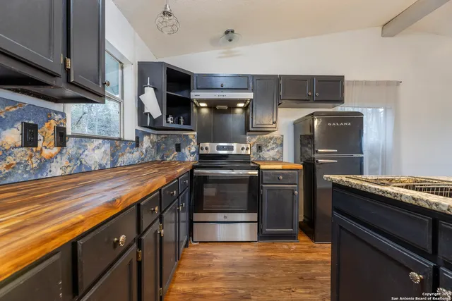 a kitchen with kitchen island granite countertop a stove top oven microwave and refrigerator
