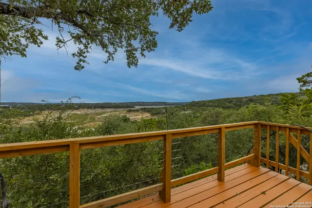 a view of a balcony with wooden floor and fence