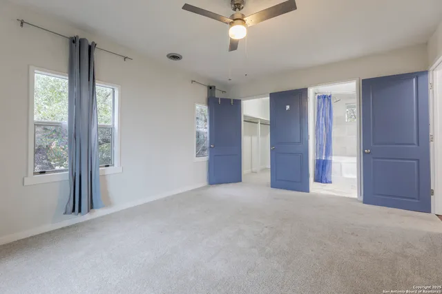 a view of empty room with window and ceiling fan