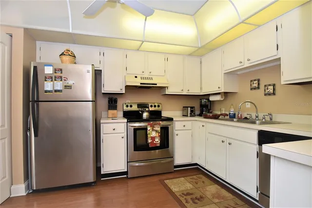 a kitchen with stainless steel appliances a refrigerator sink and cabinets