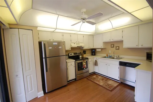 a kitchen with stainless steel appliances a refrigerator sink and cabinets