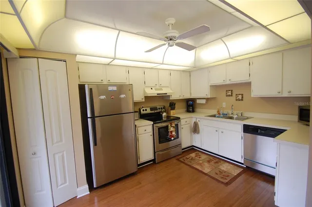 a kitchen with stainless steel appliances a refrigerator sink and cabinets