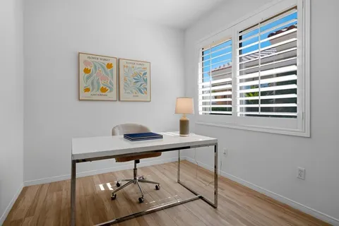 a view of a workspace with furniture and a window