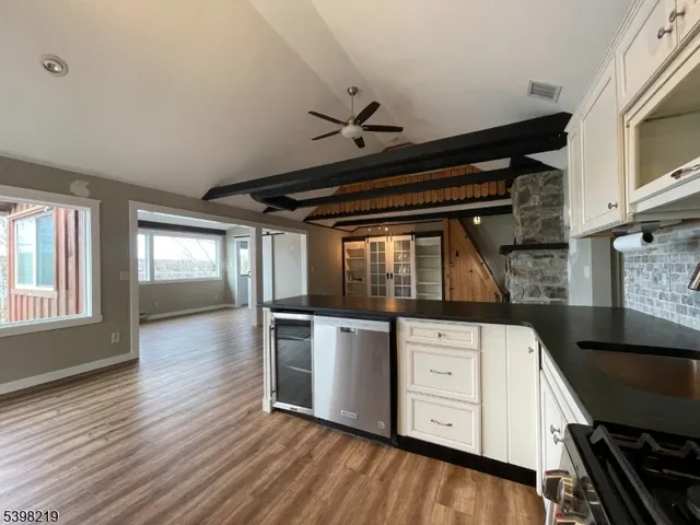 a kitchen with stainless steel appliances granite countertop a stove and a wooden floors