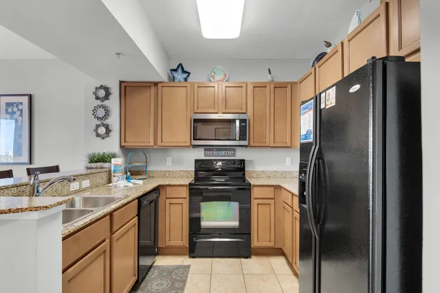 a kitchen with a sink a stove cabinets and wooden floor