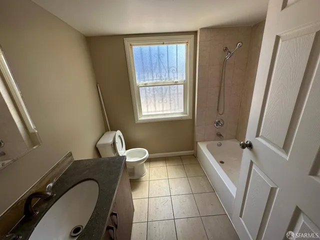 a bathroom with a tub a sink a window and a shower