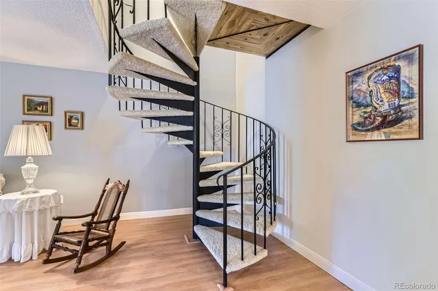 a view of a hallway with wooden floor and stairs