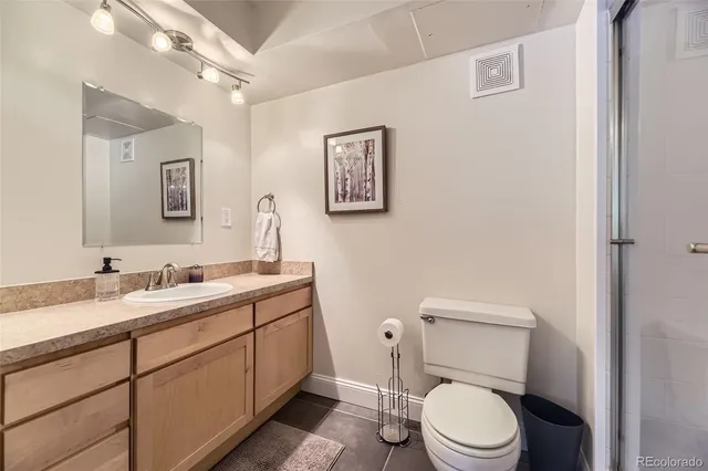 a bathroom with a toilet a sink a mirror and vanity