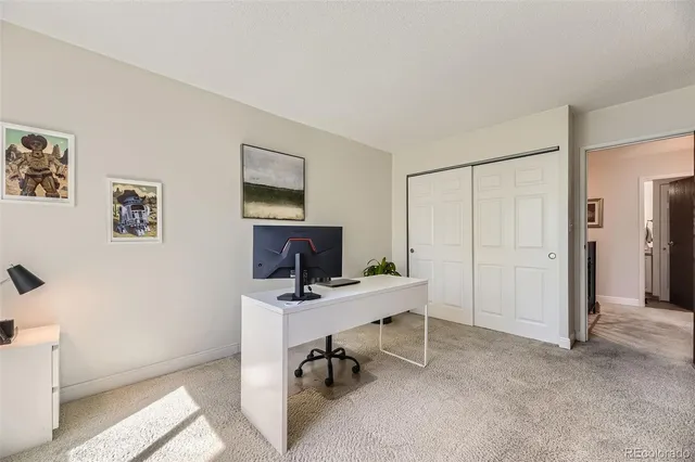 a view of a workspace with furniture and a window