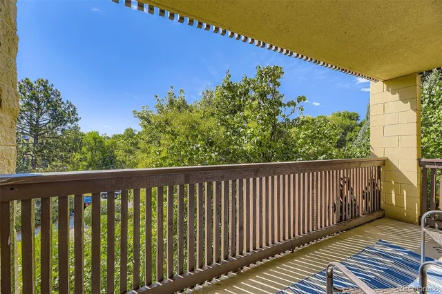 a balcony with wooden floor and yard in the back