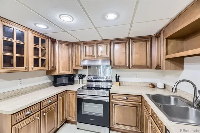 a kitchen with stainless steel appliances granite countertop a sink stove and cabinets