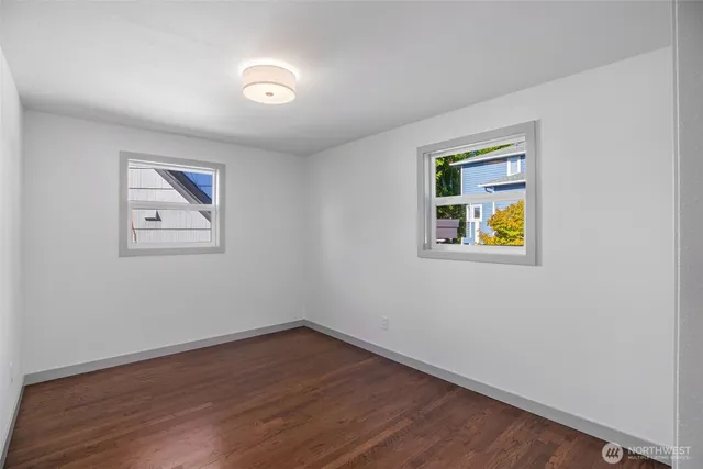 an empty room with a wooden floor and painting on the wall