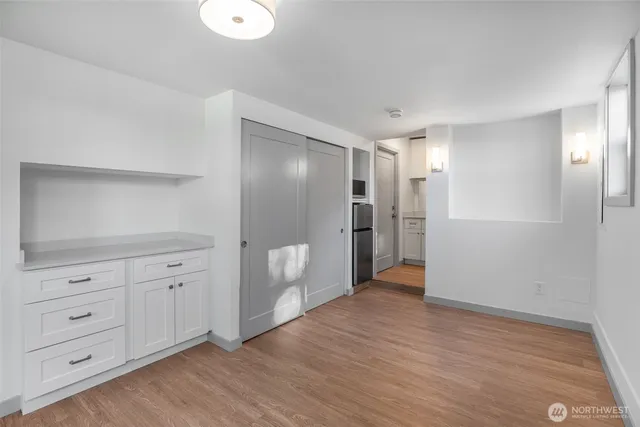 a view of an empty room with closet and wooden floor