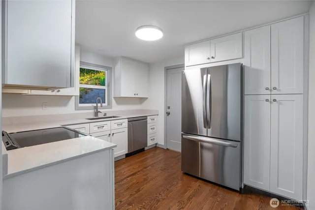 a kitchen with a refrigerator sink and cabinets