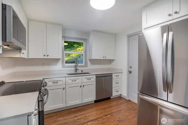 a kitchen with white cabinets and stainless steel appliances