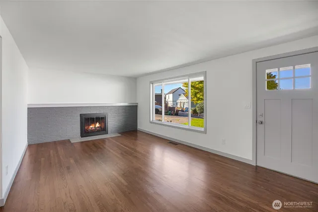 an empty room with windows and fireplace