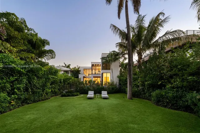 a view of a house with a backyard and a tree