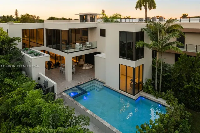 an aerial view of a house with swimming pool and deck