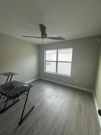 a view of a room with wooden floor and windows
