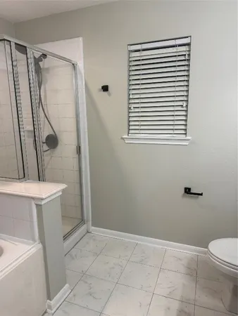 a bathroom with a toilet a sink and shower