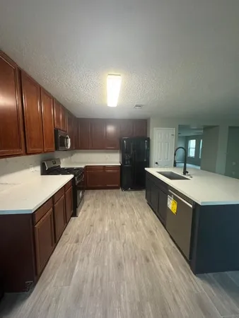 a kitchen with stainless steel appliances granite countertop a sink stove and wooden cabinets