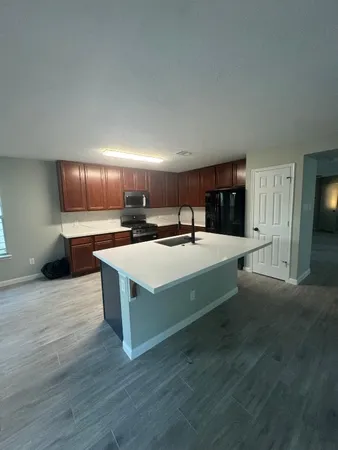 a large white kitchen with wooden floors and a fireplace