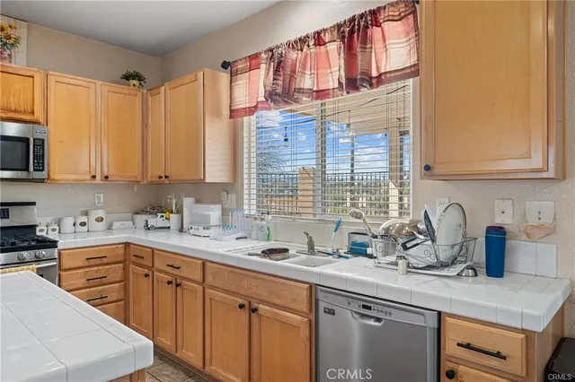 a kitchen with stainless steel appliances granite countertop a sink a stove and cabinets