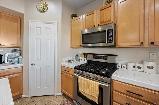 a kitchen with stainless steel appliances granite countertop a stove a microwave and a refrigerator