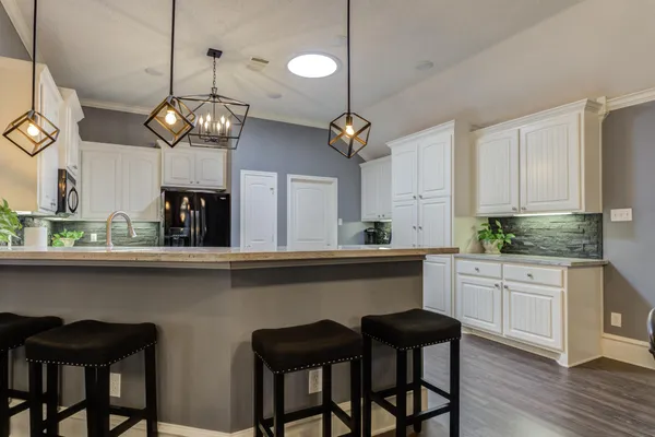 a kitchen with a dining table chairs sink and cabinets