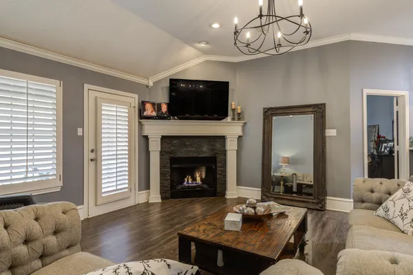 a living room with furniture a flat screen tv and a fireplace