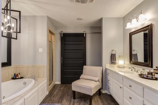 a bathroom with a tub sink and mirror