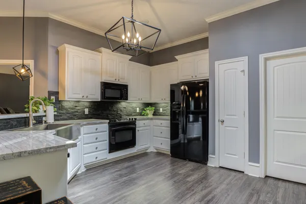 a kitchen with stainless steel appliances granite countertop a refrigerator a stove top oven a sink and dishwasher