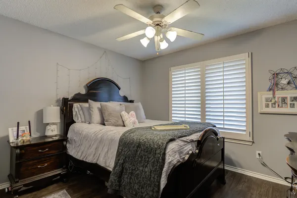 a bedroom with a bed a chandelier and a window