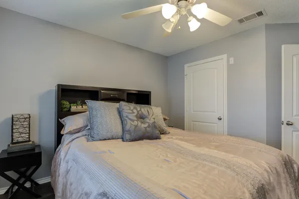 a bedroom with a large bed and a chandelier