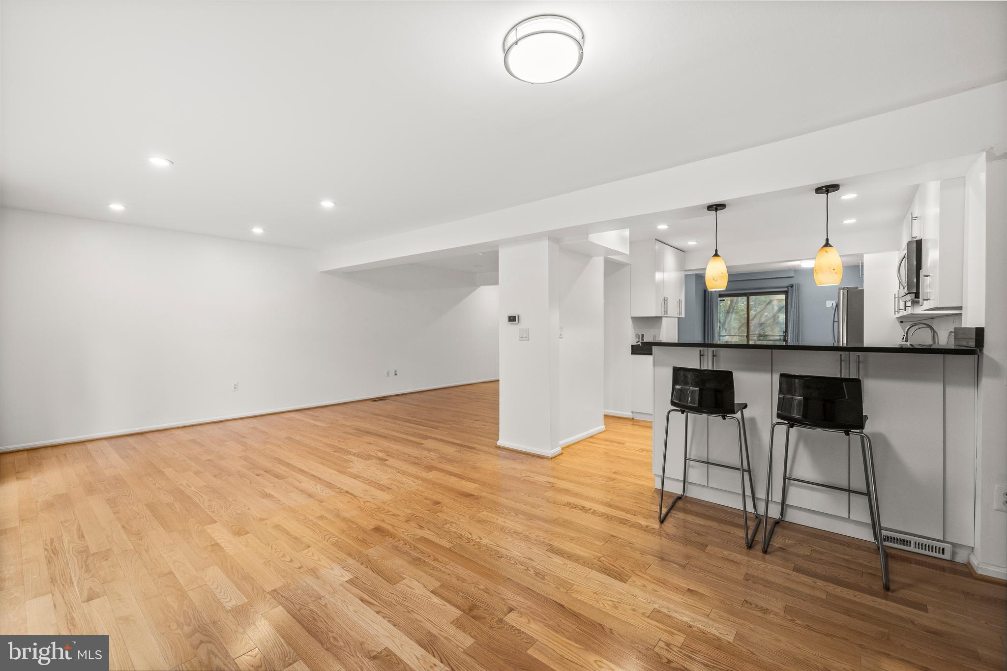 11110 Saffold Way Reston, VA 20190 - Photo 11 of 57 a kitchen with stainless steel appliances kitchen island granite countertop a table chairs and a refrigerator