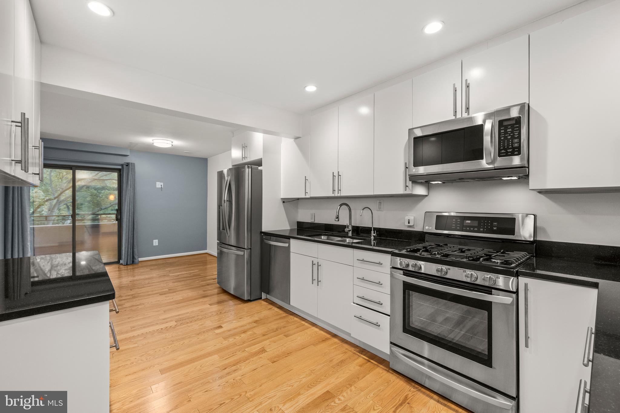 11110 Saffold Way Reston, VA 20190 - Photo 13 of 57 a kitchen with stainless steel appliances granite countertop a stove a sink and a microwave