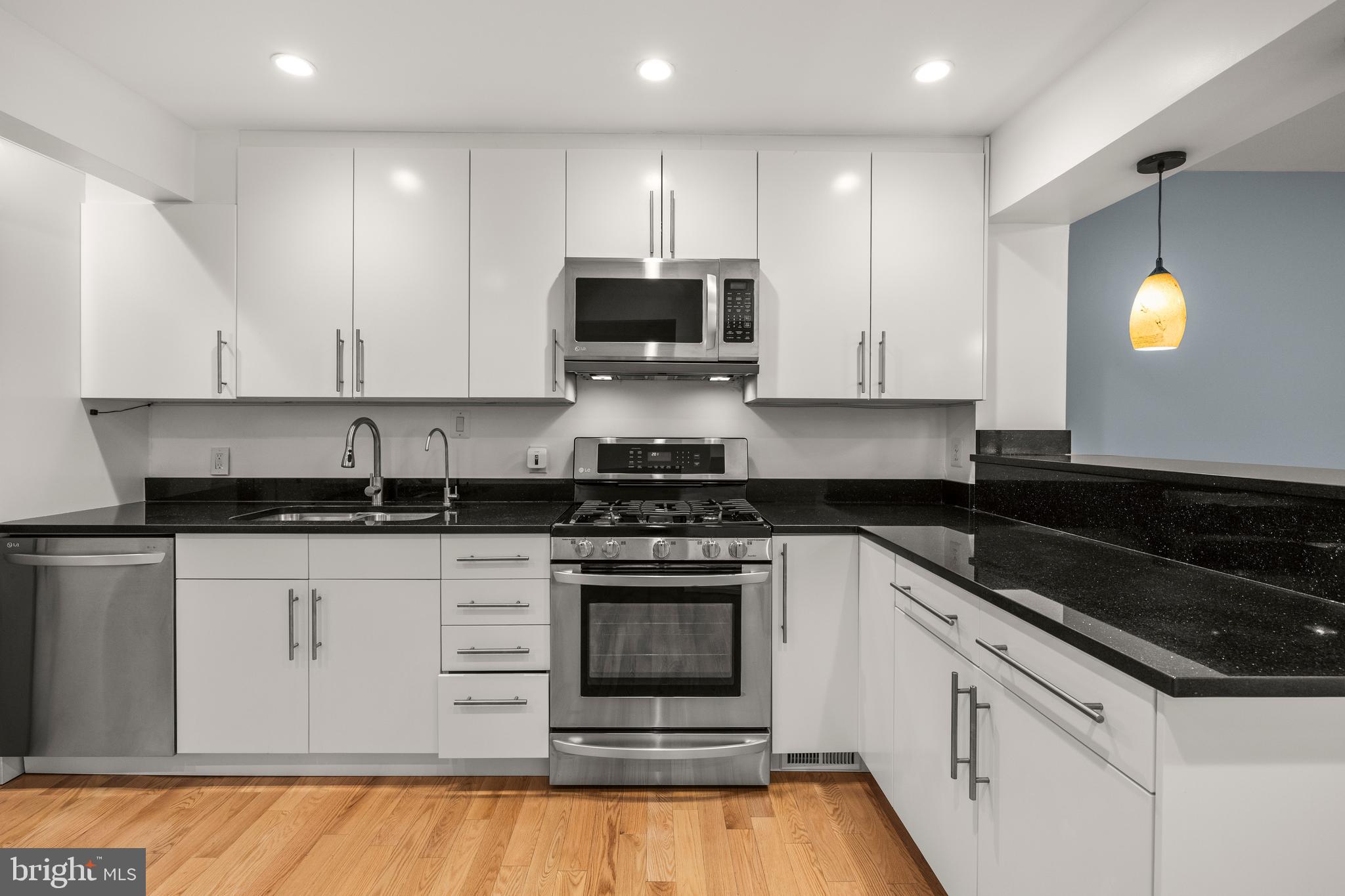 11110 Saffold Way Reston, VA 20190 - Photo 14 of 57 a kitchen with granite countertop white cabinets and stainless steel appliances
