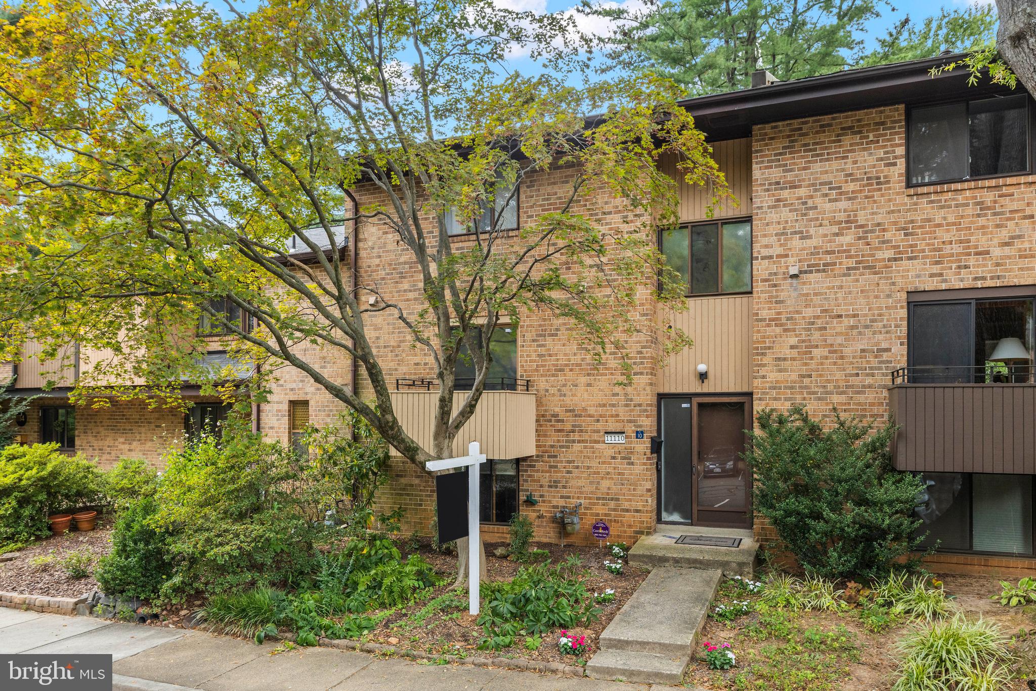 11110 Saffold Way Reston, VA 20190 - Photo 2 of 57 a front view of a house with garden
