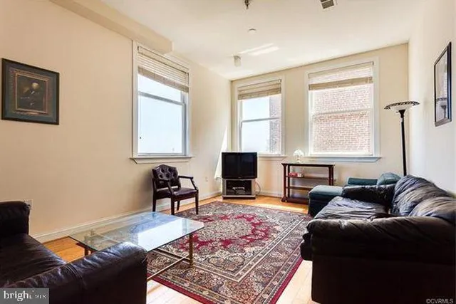 a living room with furniture rug and window