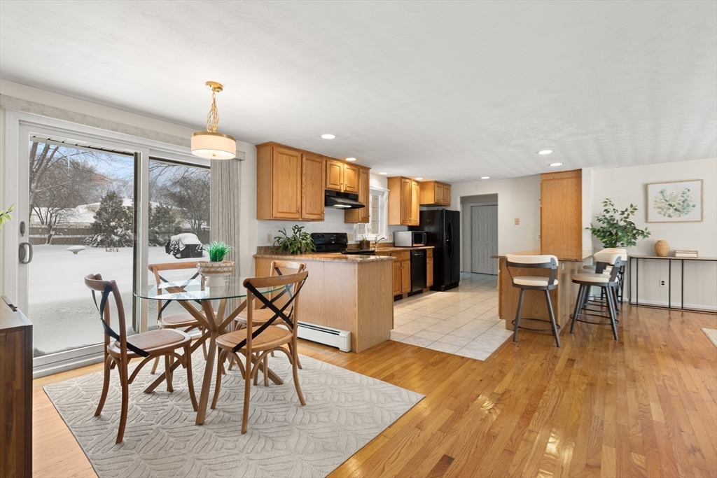 12 Tulane Road Danvers, MA 01923 - Photo 11 of 25 a kitchen with stainless steel appliances kitchen island granite countertop wooden floor and dining table