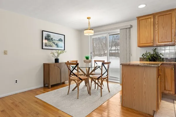a dining room with wooden floor a chandelier a wooden table and chairs